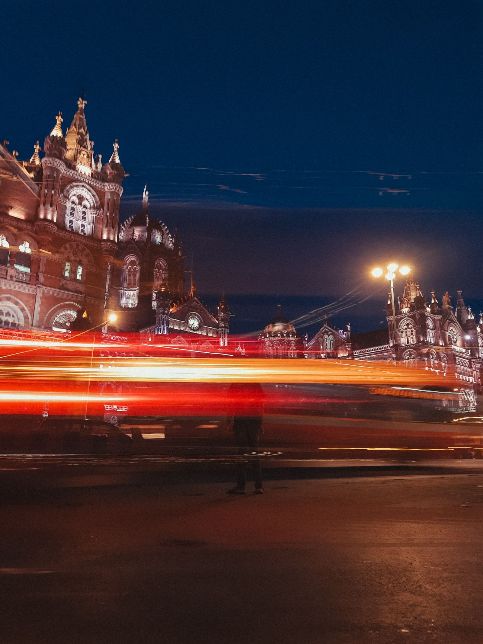 Chhatrapati Shivaji Terminus in Mumbai at night, with light trails from passing traffic.